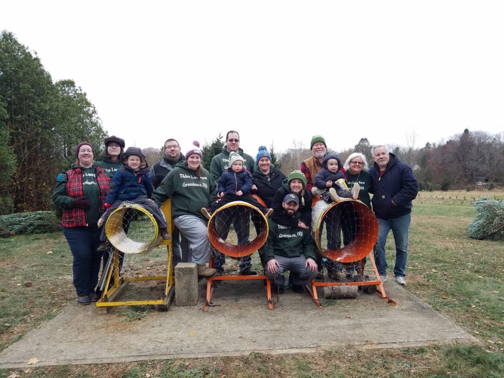 The crew poses together around the bailers at the close of the season in 2018. Logan, Nicholas, and Matthew are sitting on top of the bailers, held by their grown-ups. Behind them stand Abigail, Sanna, Jon, Emily, Mike, Rebecca, Katie, Andrew, Bruce, Jeanne, and Jimmy.